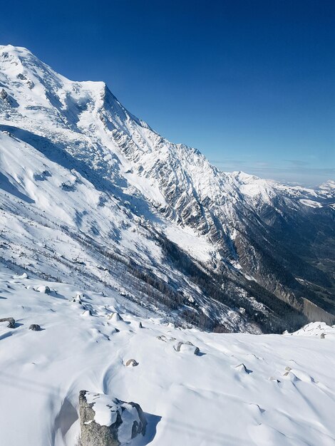 Scenic view of snowcapped mountains against blue sky