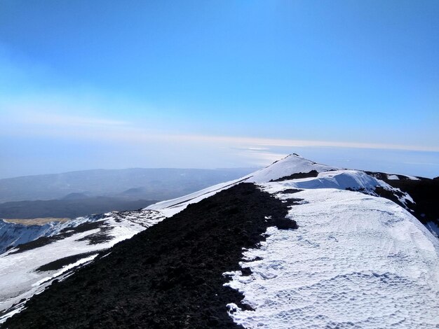 Scenic view of snowcapped mountains against blue sky