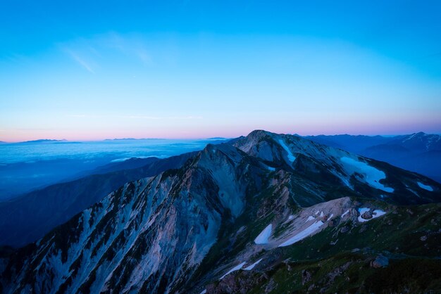 Scenic view of snowcapped mountains against blue sky