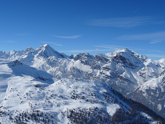 Scenic view of snowcapped mountains against blue sky