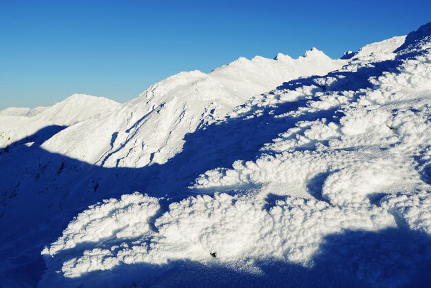 Scenic view of snowcapped mountains against blue sky