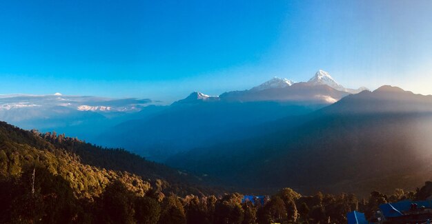 Scenic view of snowcapped mountains against blue sky