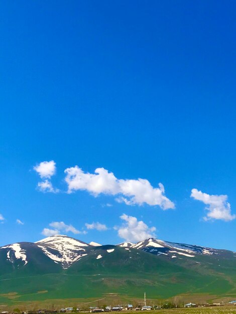 Scenic view of snowcapped mountains against blue sky