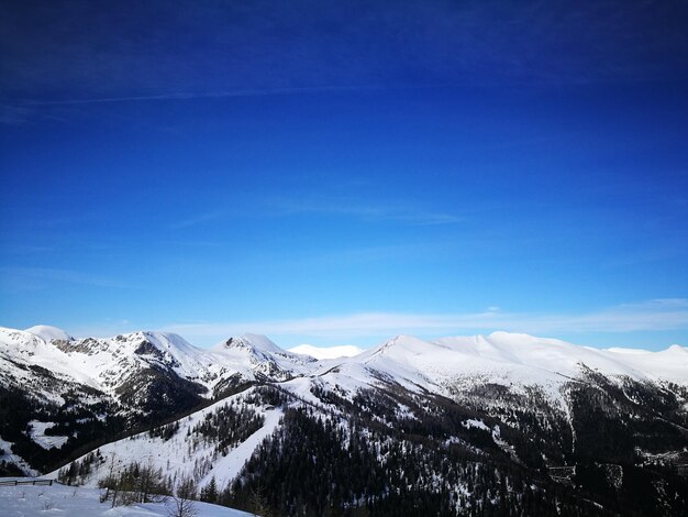 Scenic view of snowcapped mountains against blue sky