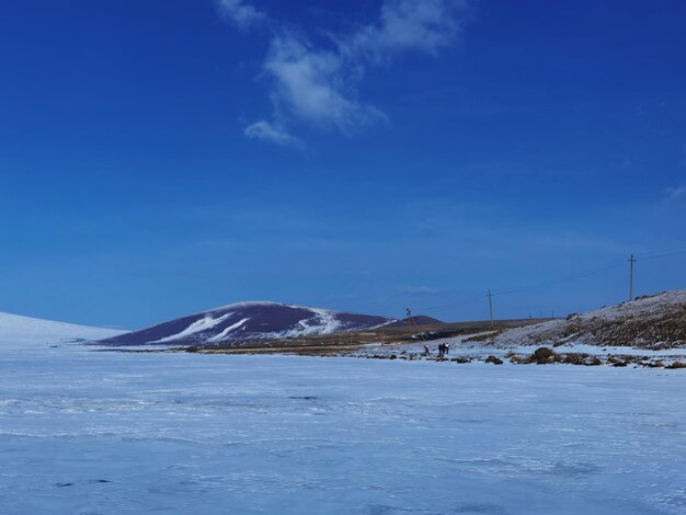 Scenic view of snowcapped mountains against blue sky