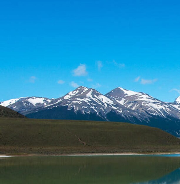 Scenic view of snowcapped mountains against blue sky