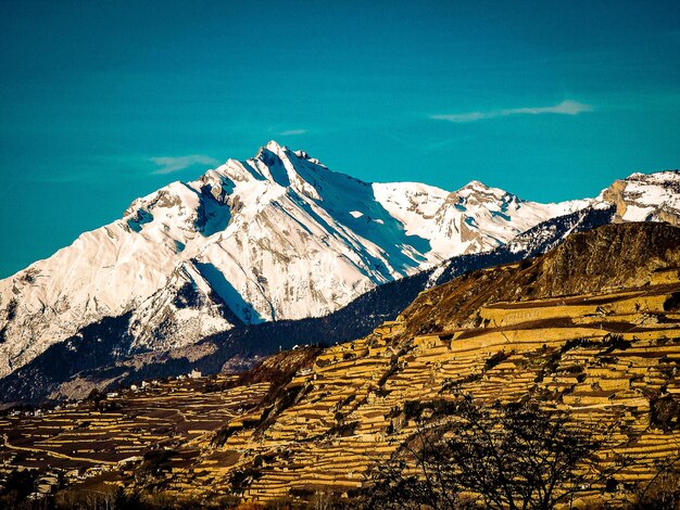 Scenic view of snowcapped mountains against blue sky