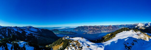 Foto la vista panoramica delle montagne innevate contro il cielo blu