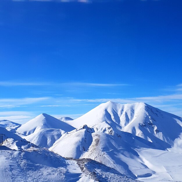 Scenic view of snowcapped mountains against blue sky