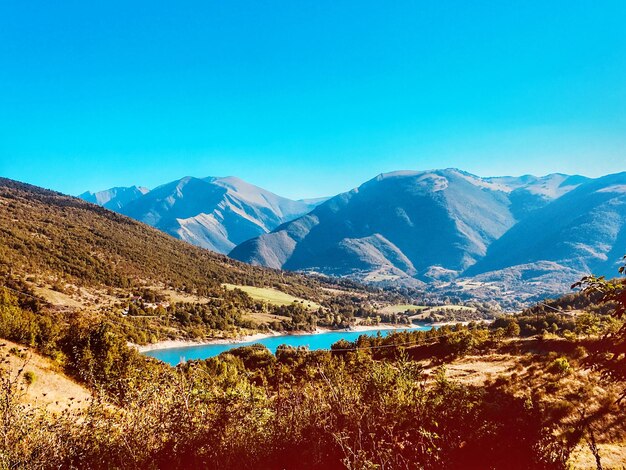 Scenic view of snowcapped mountains against blue sky