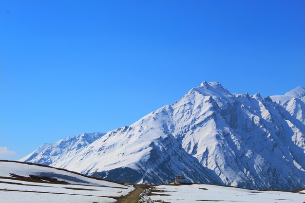 Scenic view of snowcapped mountains against clear blue sky