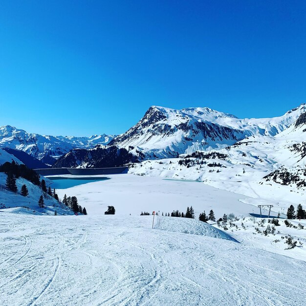 Scenic view of snowcapped mountains against clear blue sky