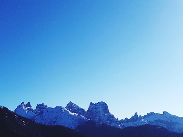 Foto la vista panoramica delle montagne innevate contro un cielo azzurro limpido