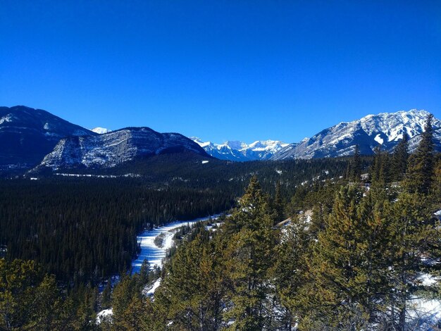 Scenic view of snowcapped mountains against clear blue sky