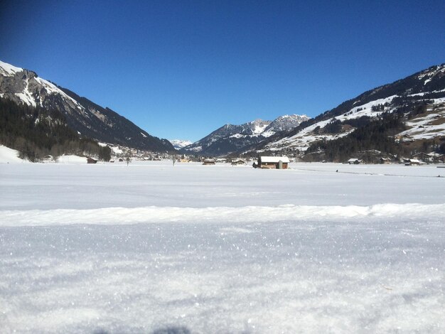 Scenic view of snowcapped mountains against clear blue sky