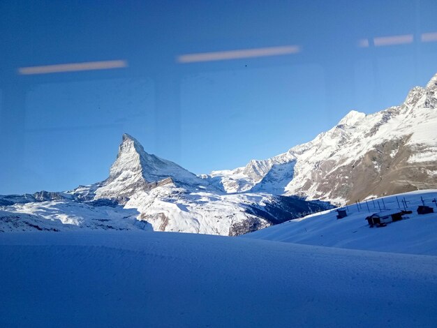 Scenic view of snowcapped mountains against clear blue sky