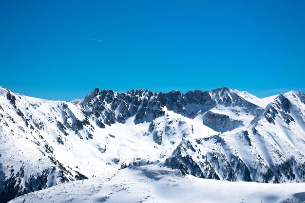 Scenic view of snowcapped mountains against clear blue sky