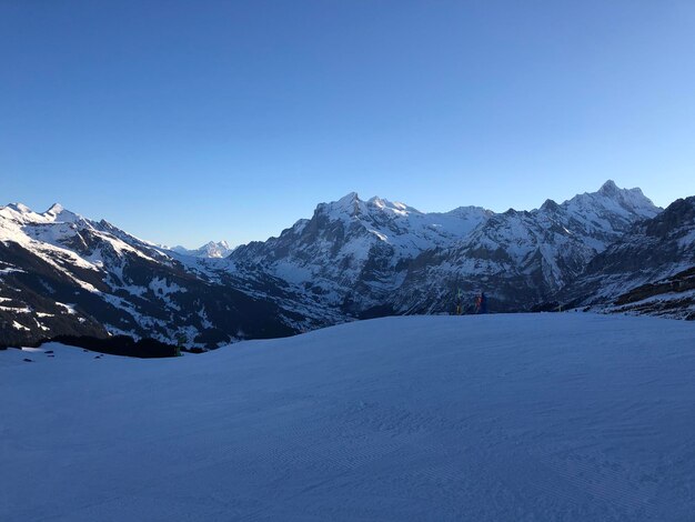 Scenic view of snowcapped mountains against clear blue sky