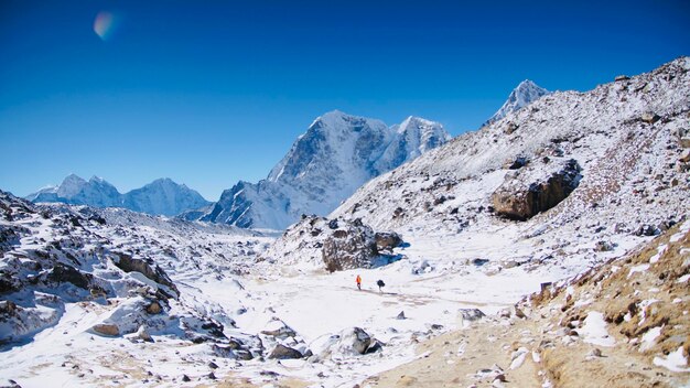 Scenic view of snowcapped mountains against clear blue sky