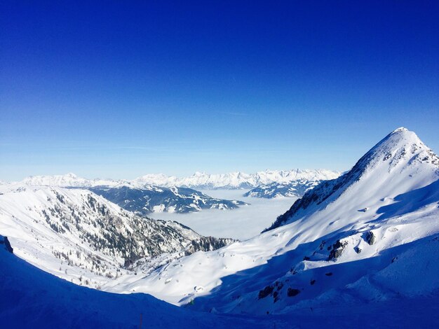 Scenic view of snowcapped mountains against clear blue sky