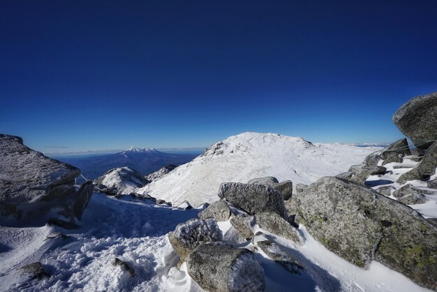 Scenic view of snowcapped mountains against clear blue sky