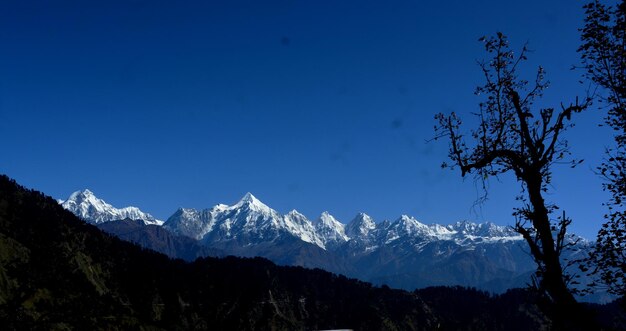 Scenic view of snowcapped mountains against clear blue sky