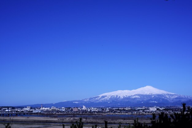 Scenic view of snowcapped mountains against clear blue sky