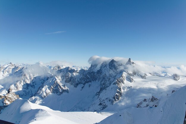 Foto la vista panoramica delle montagne innevate contro un cielo azzurro limpido