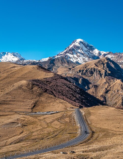 Scenic view of snowcapped mountains against clear blue sky