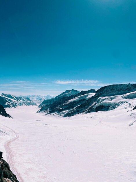 Scenic view of snowcapped mountains against clear blue sky