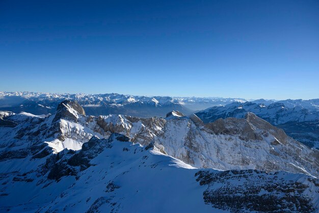 Scenic view of snowcapped mountains against clear blue sky