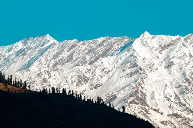 Scenic view of snowcapped mountains against clear blue sky