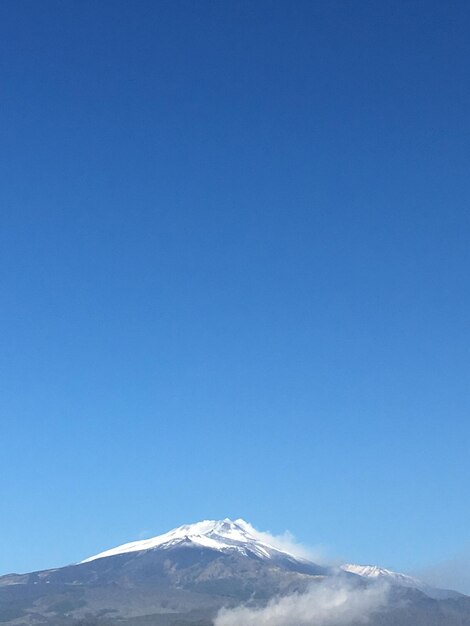 Scenic view of snowcapped mountains against clear blue sky