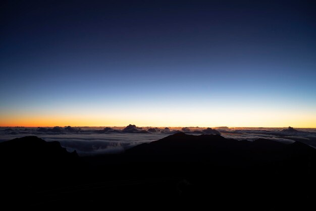 Scenic view of snowcapped mountains against clear sky during sunset