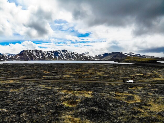 Scenic view of snowcapped mountains against cloudy sky