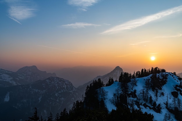 Photo scenic view of snowcapped mountains against sky during sunset