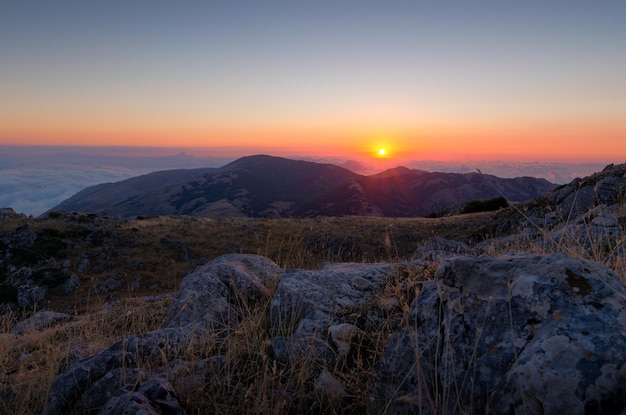 Photo scenic view of snowcapped mountains against sky during sunset