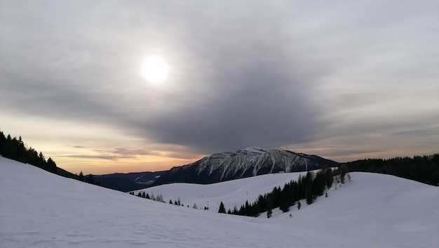 Scenic view of snowcapped mountains against sky during sunset