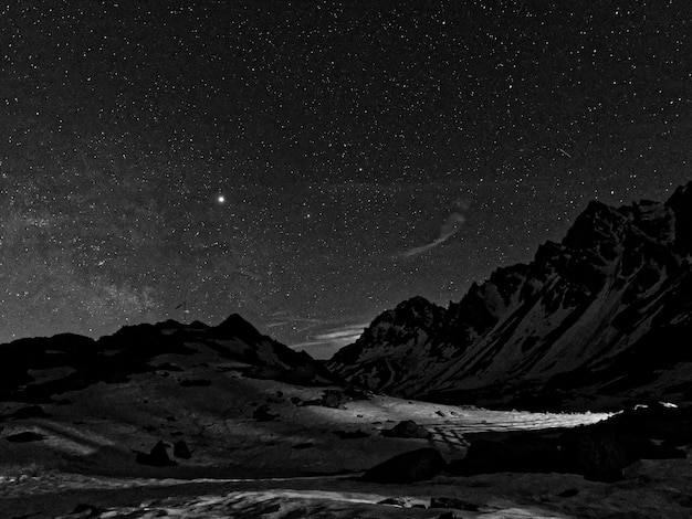 Photo scenic view of snowcapped mountains against sky at night