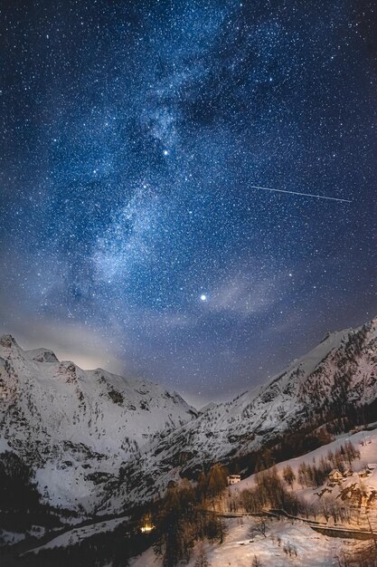 Scenic view of snowcapped mountains against sky at night