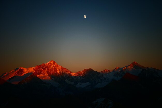 Foto la vista panoramica delle montagne innevate contro il cielo al tramonto