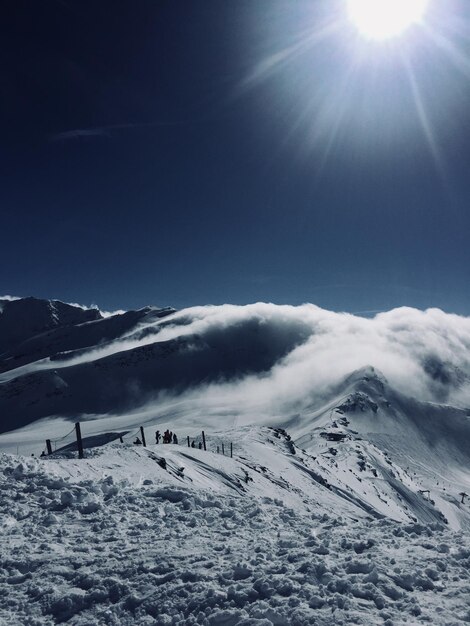 天空 に 対し て 雪 に 覆わ れ た 山 の 景色