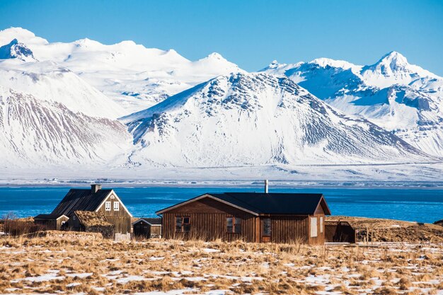 Scenic view of snowcapped mountains by sea against sky