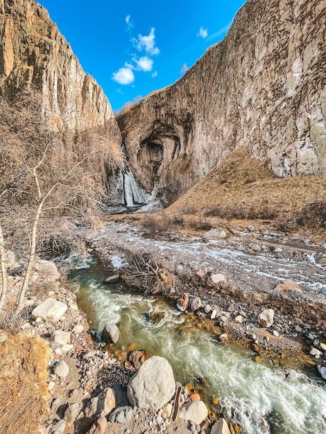 Scenic view of stream flowing through rocks against sky