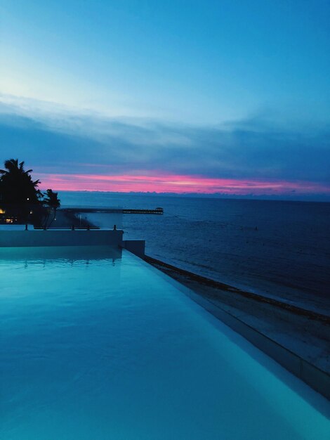 Scenic view of swimming pool against sky at sunset