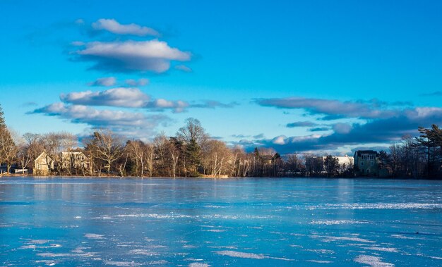 Scenic view of swimming pool by lake against blue sky