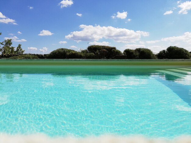 Scenic view of swimming pool by lake against sky