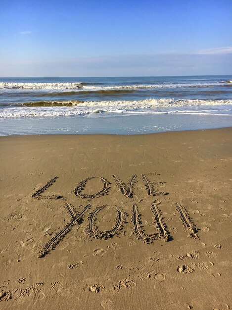 Photo scenic view of text on beach against sky