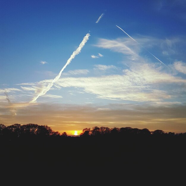 Scenic view of vapor trail against sky during sunset