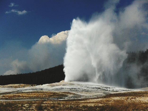 Photo scenic view of water spraying from geyser against sky